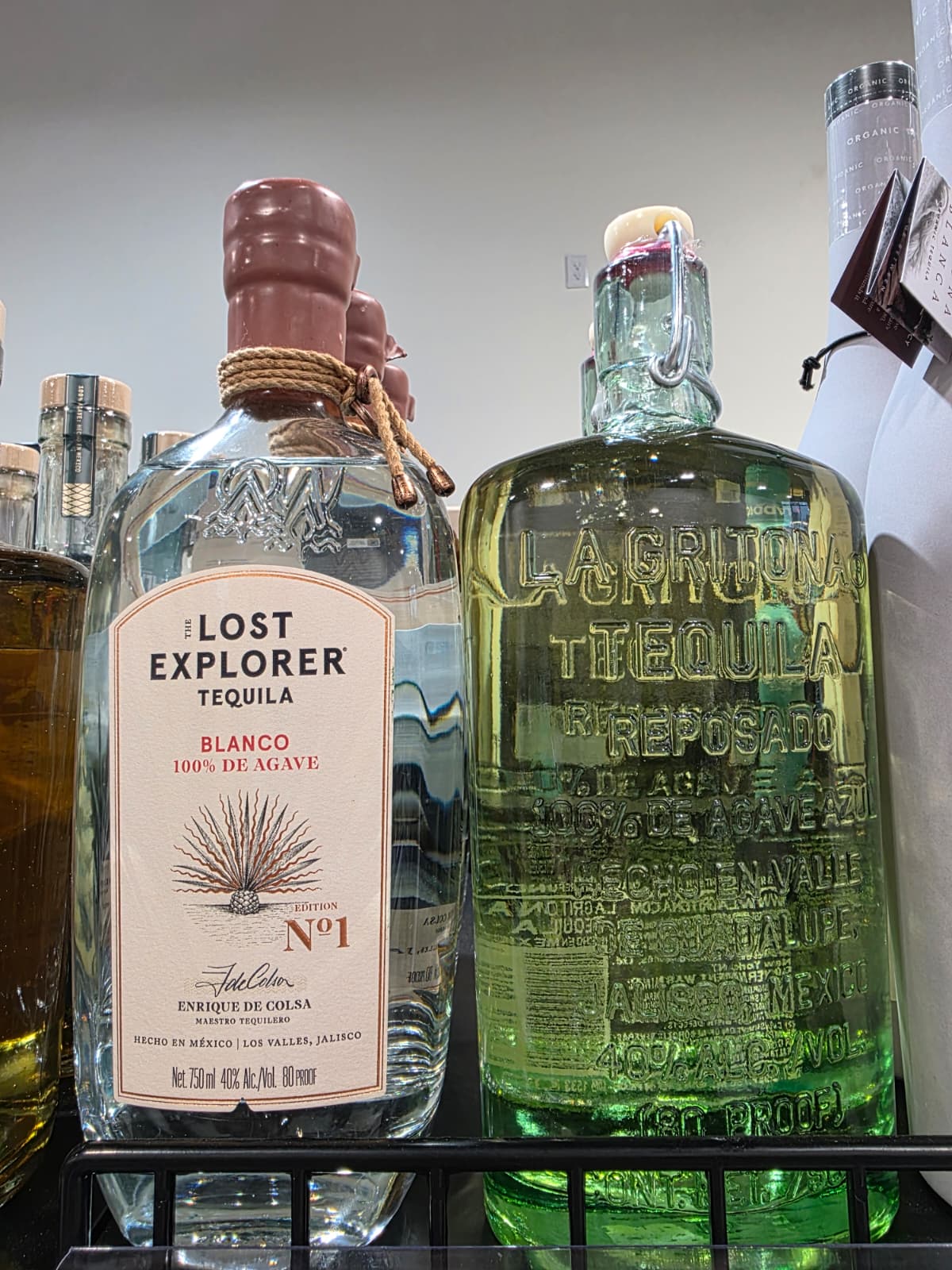 The Lost Explorer Blanco beside an embossed La Gritona Reposado bottle